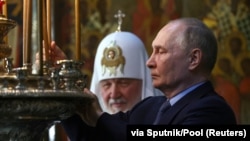 Vladimir Putin və arxa planda Rusiya patriarxı Kirill (Arxiv fotosu)