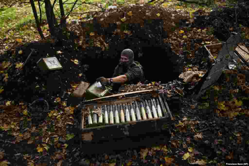 Украинский сапер открывает ящик с боеприпасами на брошенной российской позиции