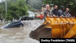 Людей вытаскивают ковшом экскаватора во время наводнения в Сочи в 2015 году, архивная фотография