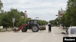 Қарулы шабуылға күдіктілерге қарсы арнайы операция жүріп жатқан жерде көшені бақылап тұрған полиция қызметкері. Ақтөбе, 10 маусым 2016 жыл.