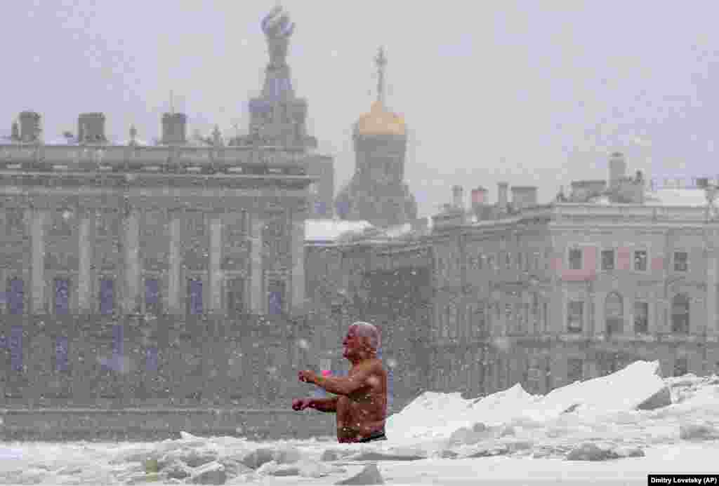 Мужчина купается в проруби в Санкт-Петербурге, Россия. Температура в Санкт-Петербурге &ndash; минус 15 по Цельсию. (AP/Дмитрий Ловецкий)