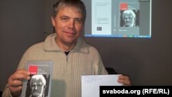 Алесь Капуцкі зь лістом ад Алеся Бяляцкага і кнігай Свабоды пра яго. 2013 год