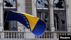 Bosnia-Herzegovina -- A Bosnian and Herzegovina national flag is seen on a damaged government building in Sarajevo February 8, 2014.