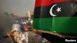 Libya -- Protesters burn pictures of Libyan leader Muammar Qaddafi and copies of the Green book, in Benghazi, 02Mar2011