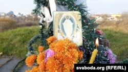 Кветкі і запаленая сьвечка ў памяць пра бязьвінна забітых