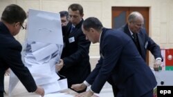 Belarus -- Electoral commission staff empties a ballot box after polling stations closed during during presidential elections in Minsk, Belarus, 11 October 2015. 