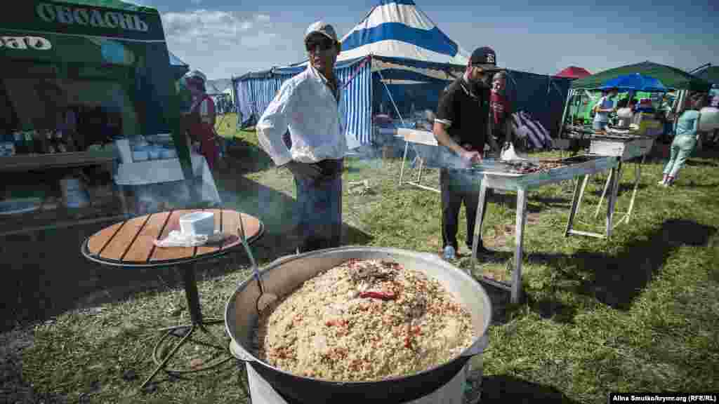 Мужчина готовит плов и шашлыки