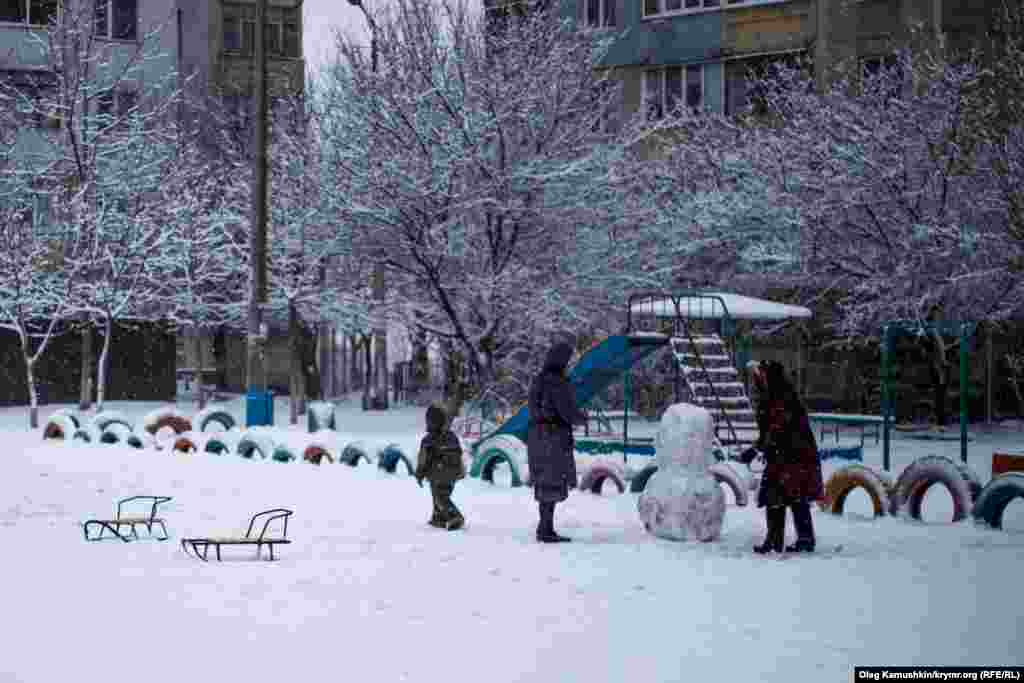 Пока дети играют, взрослые лепят снеговика.&nbsp;