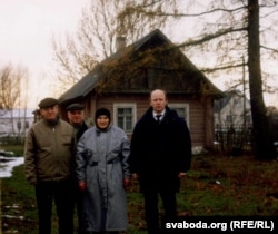 Алесь Чахольскі, Сяргей Папкоў і Юрась Беленькі разам з Ганнай Яўхімаўннай Пазьняк ля яе роднай хаты. Суботнікі, 2002 г.