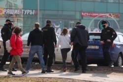 Затрымалі дзяўчыну на вуліцы Сурганава каля плошчы. У руках сілавіка бачная агараджальная стужка.