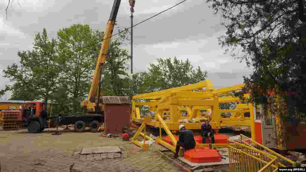 Монтаж нового колеса обозрения на городской набережной Керчи. Рабочие отдыхают во время перерыва