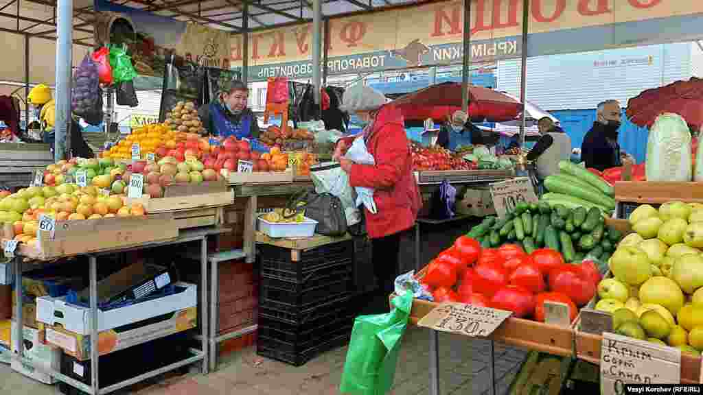 На центральном рынке многие продавцы носят защитные маски на подбородке