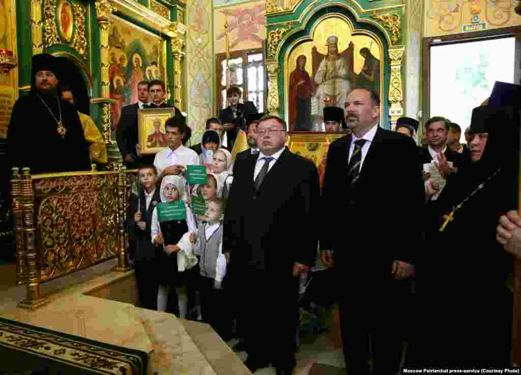 Местные чиновники во время службы. Лица напряжены