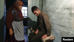 Russia -- Alik Nuryshev, 20, a local resident suffering from childhood disability including epilepsy and cerebral palsy, sits in his house in the village of Muslyumovo, 18Nov2010