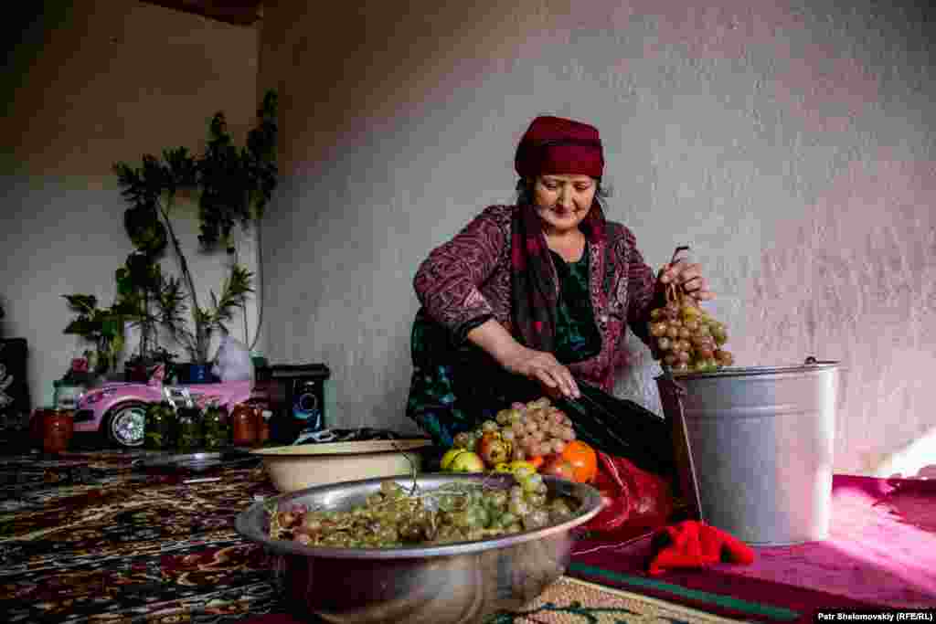 Модари Зарина хӯшаҳои ангурро пок мекунад.