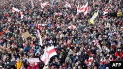 BELARUS – Opposition supporters carrying former white-red-white flags of Belarus parade through the streets during a rally to protest against the Belarus presidential election results in Minsk on October 18, 2020